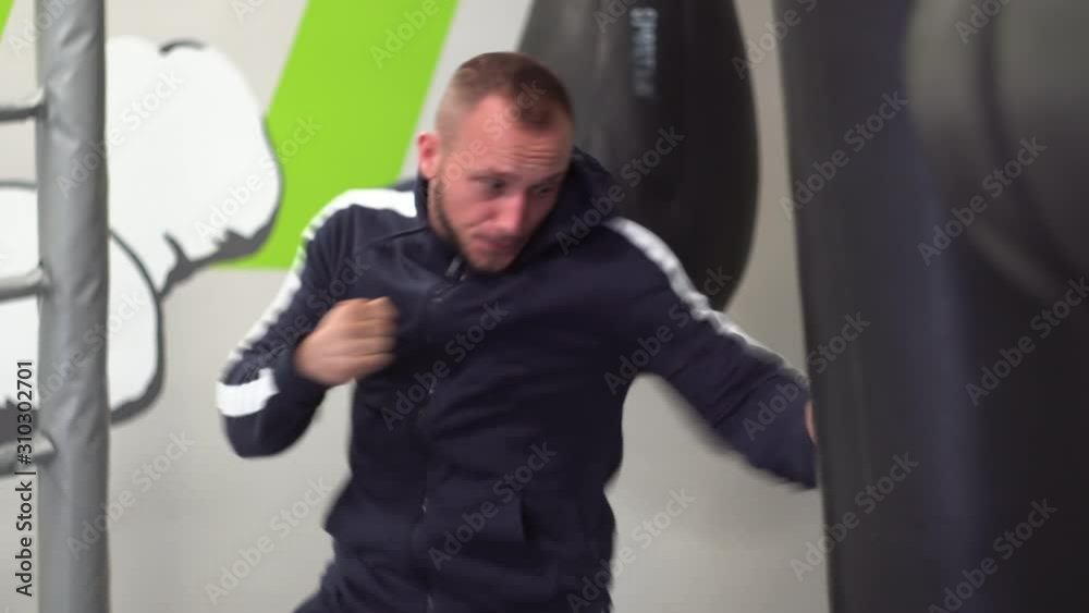 Young muscular athlete fulfills kick. Sports man having cardio training at fitness gym Young muscular athlete fulfills kick. Sports man having cardio training at fitness gym