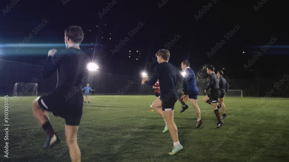Soccer football players during the team training before the match. Exercises for football soccer youth team. Young player exercises with ball and marker cones, running training rugby men athlete