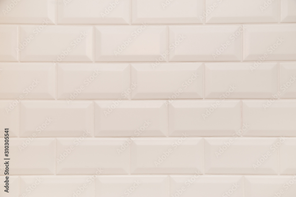 Bathroom wall tiled in scandinavian style with white grouting.