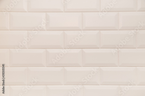 Bathroom wall tiled in scandinavian style with white grouting.