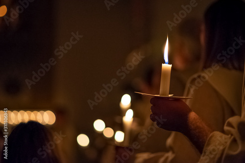People are handling candles in the traditionall religious habit dresses in the church. Celebration of Lucia day, Sweden
