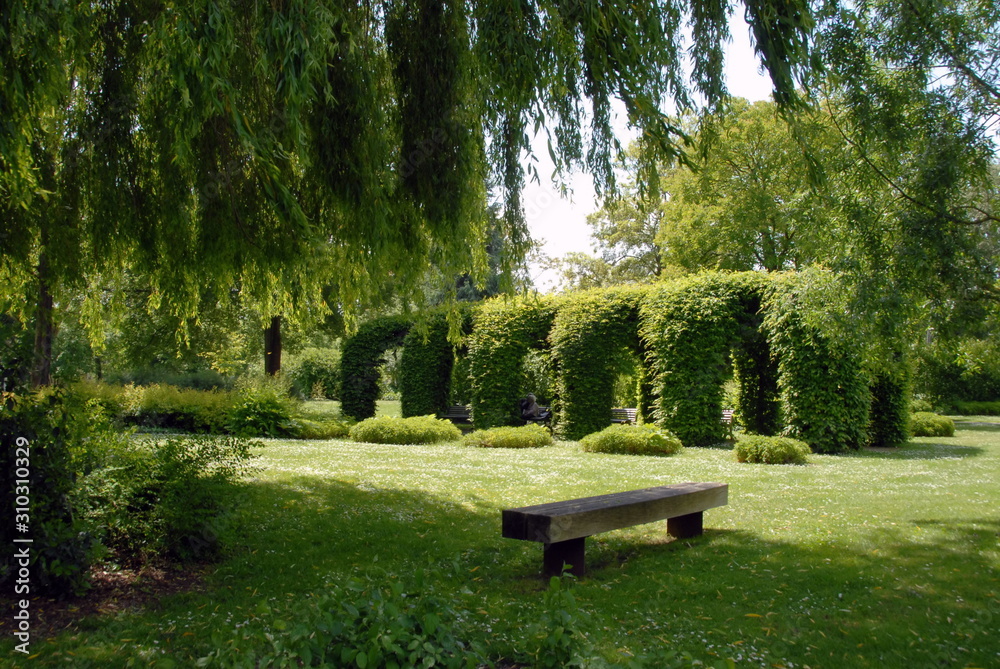 Ville d'Argentan, jardin public et un banc en premier plan, département de l'Orne Ville d'Argentan, jardin public et un banc en premier plan, département de l'Orne