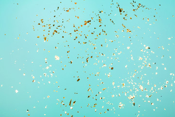 Golden flying sparkles on blue holiday background. Festive backdrop for your projects.
