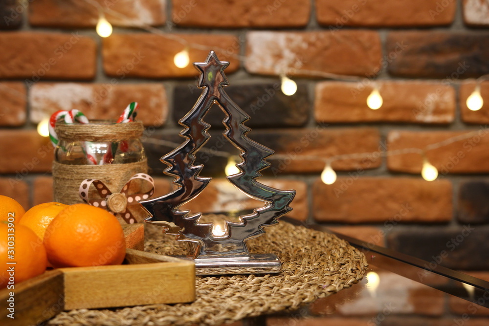 Christmas decoration - silver christmas tree candle holder with tangerines on the brick wall