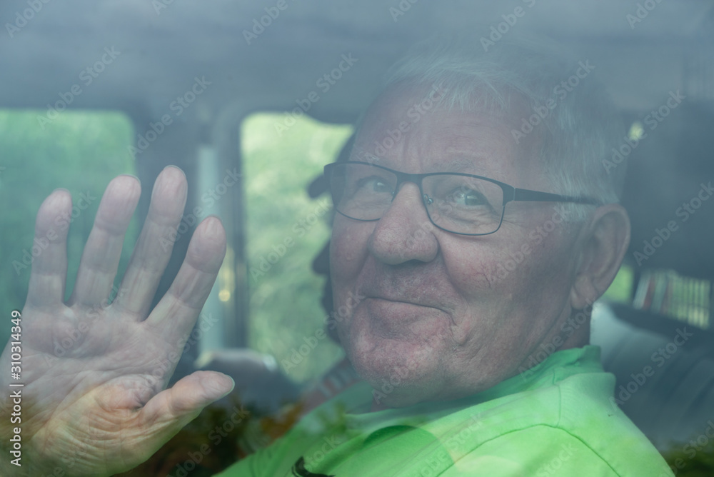 custom made wallpaper toronto digitalLächelnder Senior winkt in einem Auto hinter einer Scheibe