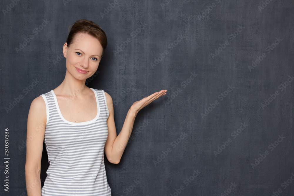 Portrait of happy girl smiling and pointing at copy space on right