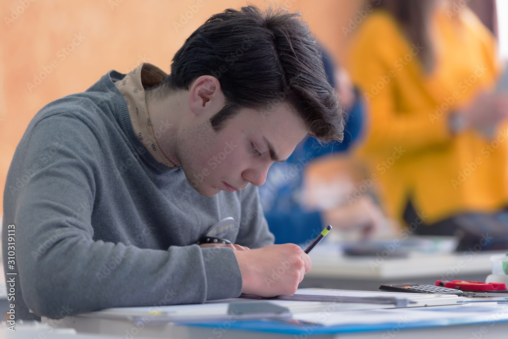 Male university architecture student working on practice lessons. Looking for solution during class. Male university architecture student working on practice lessons. Looking for solution during class.