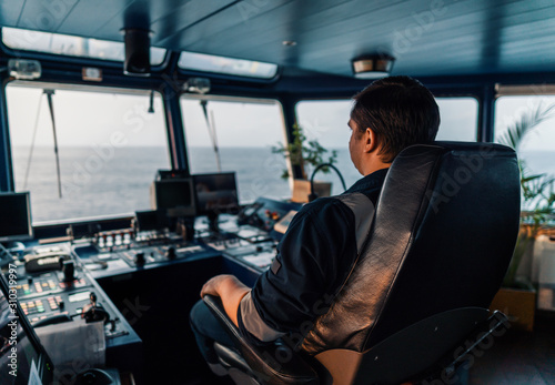 Marine navigational officer during navigational watch on Bridge . Work at sea photo