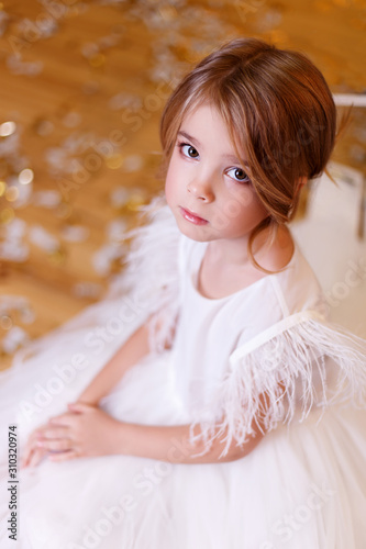  Little girl with blond hair. Portrait of a little girl. Cute little blonde girl in a beautiful white dress.