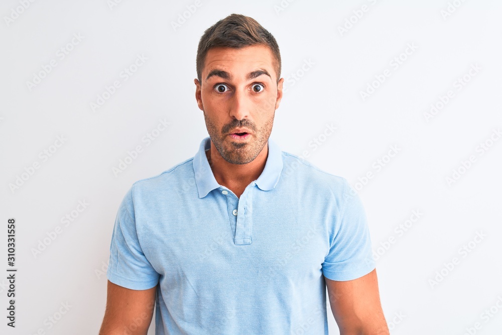 Young handsome elegant man wearing blue t-shirt over isolated background afraid and shocked with surprise expression, fear and excited face. Young handsome elegant man wearing blue t-shirt over isolated background afraid and shocked with surprise expression, fear and excited face.