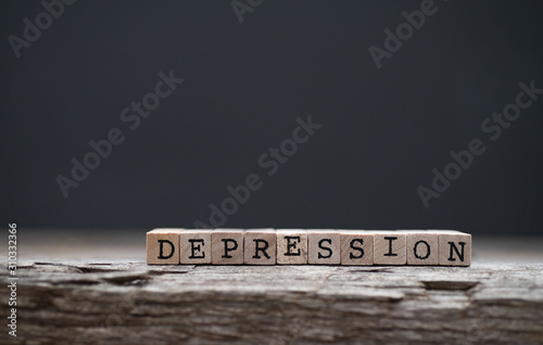The word depression on a wood background and dark background