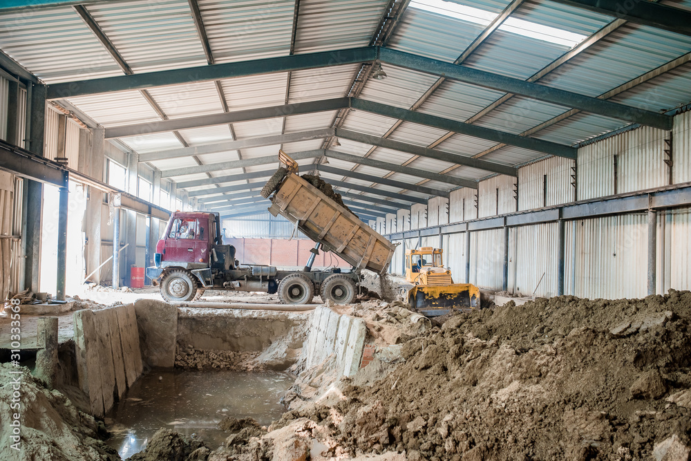 Fototapeta premium Plant for the production of bricks from clay. Plant for production building material with ready brick, construction industrial. Production of bricks on plant. Workflow, close-up. Many bricks