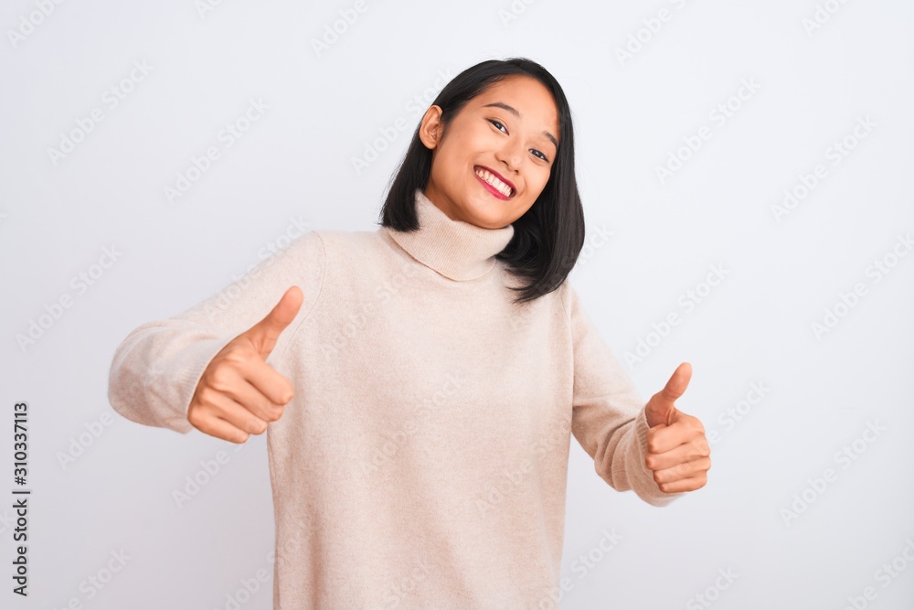 Young chinese woman wearing turtleneck sweater standing over isolated white background approving doing positive gesture with hand, thumbs up smiling and happy for success. Winner gesture. Young chinese woman wearing turtleneck sweater standing over isolated white background approving doing positive gesture with hand, thumbs up smiling and happy for success. Winner gesture.