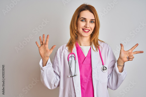 Redhead caucasian doctor woman wearing pink stethoscope over isolated background showing and pointing up with fingers number eight while smiling confident and happy.