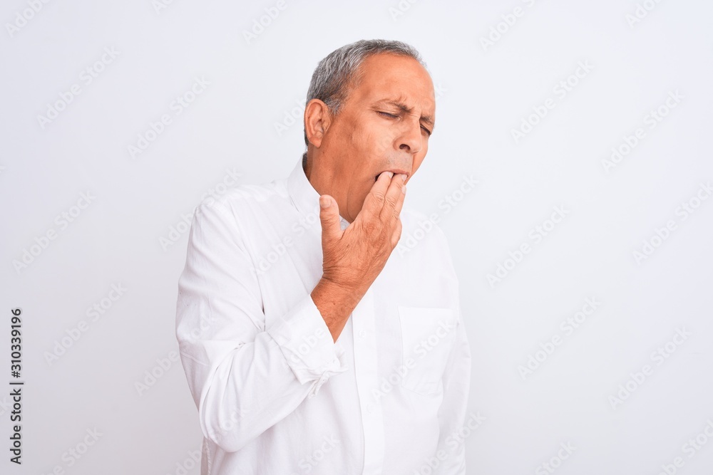 Senior grey-haired man wearing elegant shirt standing over isolated white background bored yawning tired covering mouth with hand. Restless and sleepiness.