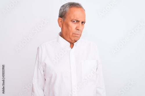 Senior grey-haired man wearing elegant shirt standing over isolated white background depressed and worry for distress, crying angry and afraid. Sad expression.