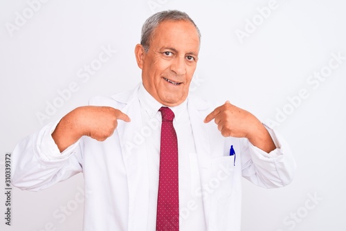 Senior grey-haired scientist man wearing coat standing over isolated white background looking confident with smile on face, pointing oneself with fingers proud and happy. © Krakenimages.com