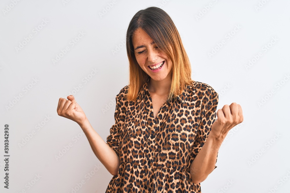 Beautiful redhead woman wearing elegant animal print shirt over isolated background very happy and excited doing winner gesture with arms raised, smiling and screaming for success. Celebration concept Beautiful redhead woman wearing elegant animal print shirt over isolated background very happy and excited doing winner gesture with arms raised, smiling and screaming for success. Celebration concept