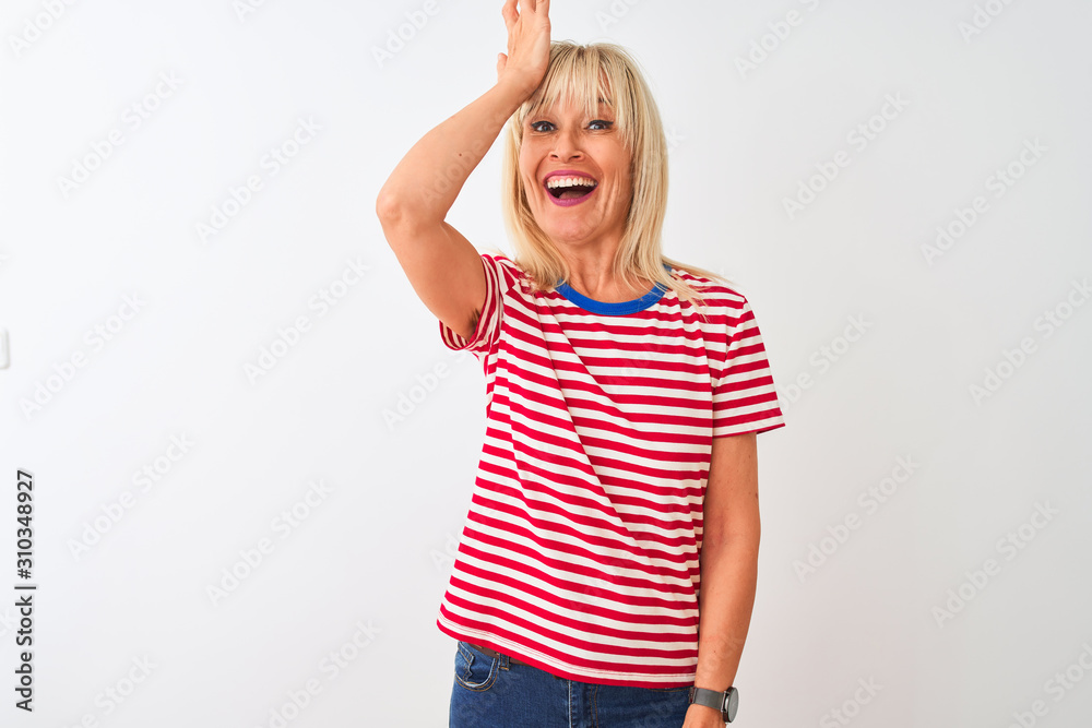 Middle age woman wearing casual striped t-shirt standing over isolated white background surprised with hand on head for mistake, remember error. Forgot, bad memory concept.