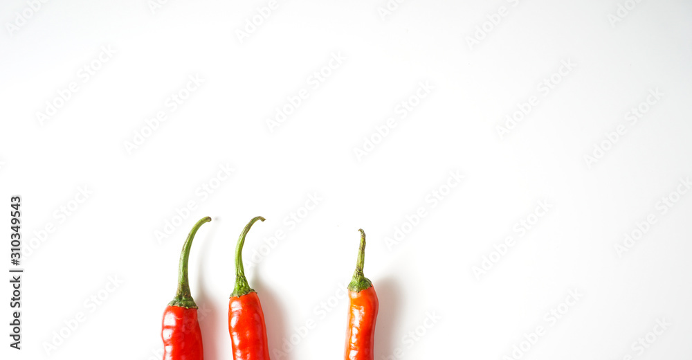 Top view stalk of red hot chili pepper over white background.