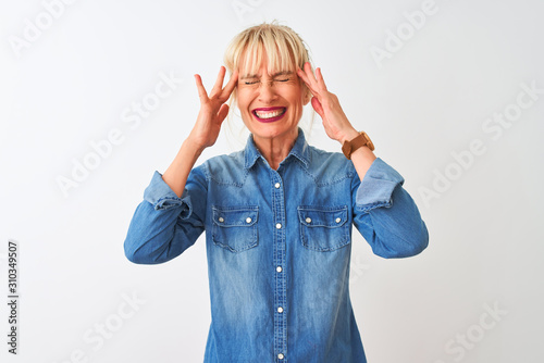 Middle age woman wearing casual denim shirt standing over isolated white background with hand on head for pain in head because stress. Suffering migraine.