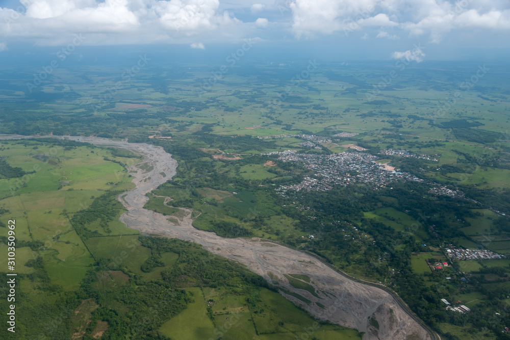 Aerial view of the river with little water, with a nearby town and agricultural crops around. Department of Córdoba Colombia