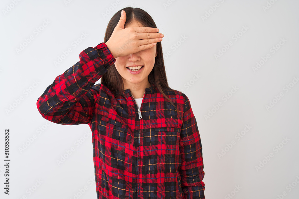 Young chinese woman wearing casual jacket standing over isolated white background smiling and laughing with hand on face covering eyes for surprise. Blind concept. Young chinese woman wearing casual jacket standing over isolated white background smiling and laughing with hand on face covering eyes for surprise. Blind concept.