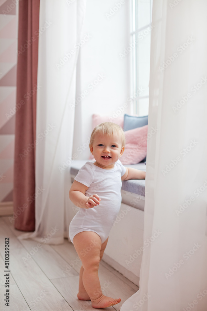 a small child learns to walk by the window a small child learns to walk by the window