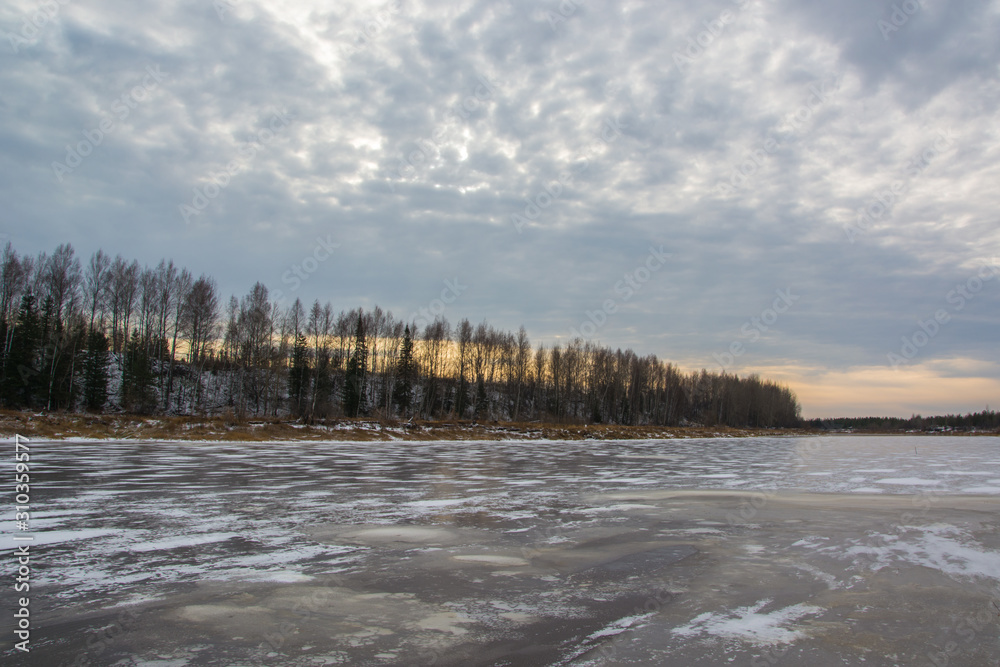The river is covered with thin ice. Autumn evening. The river is covered with thin ice. Autumn evening.
