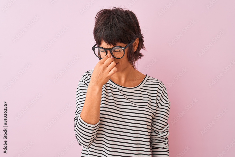 Young beautiful woman wearing striped t-shirt and glasses over isolated pink background tired rubbing nose and eyes feeling fatigue and headache. Stress and frustration concept. Young beautiful woman wearing striped t-shirt and glasses over isolated pink background tired rubbing nose and eyes feeling fatigue and headache. Stress and frustration concept.