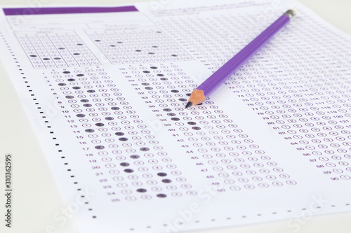 Student filling out answers to purple answer sheet with purple pencil.