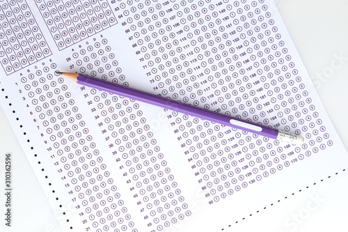 Student filling out answers to purple answer sheet with purple pencil.