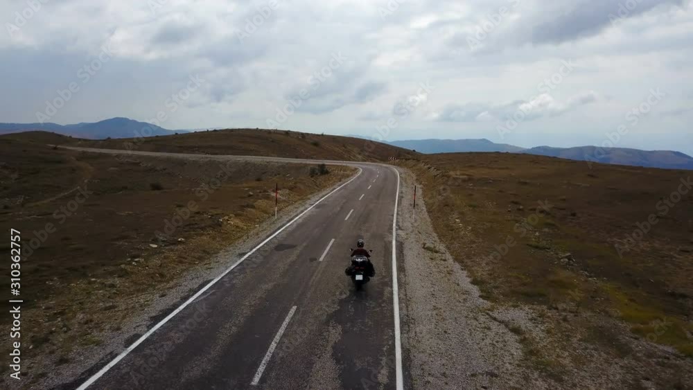 Motorbike rider riding in golden nature of steppe highway, Anatolia Motorbike rider riding in golden nature of steppe highway, Anatolia