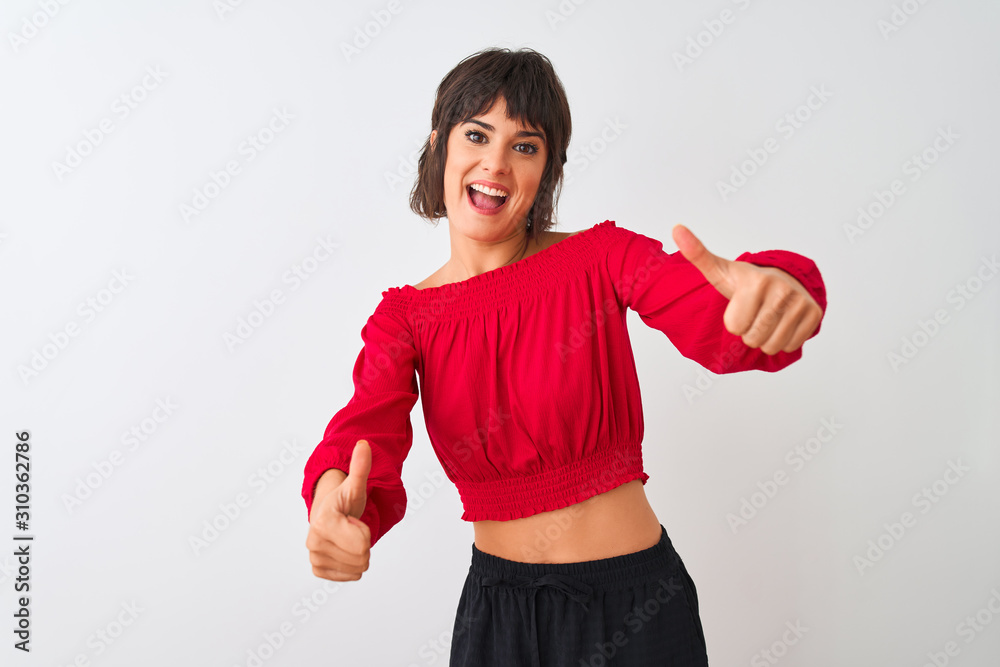 Young beautiful woman wearing red summer t-shirt standing over isolated white background approving doing positive gesture with hand, thumbs up smiling and happy for success. Winner gesture. Young beautiful woman wearing red summer t-shirt standing over isolated white background approving doing positive gesture with hand, thumbs up smiling and happy for success. Winner gesture.