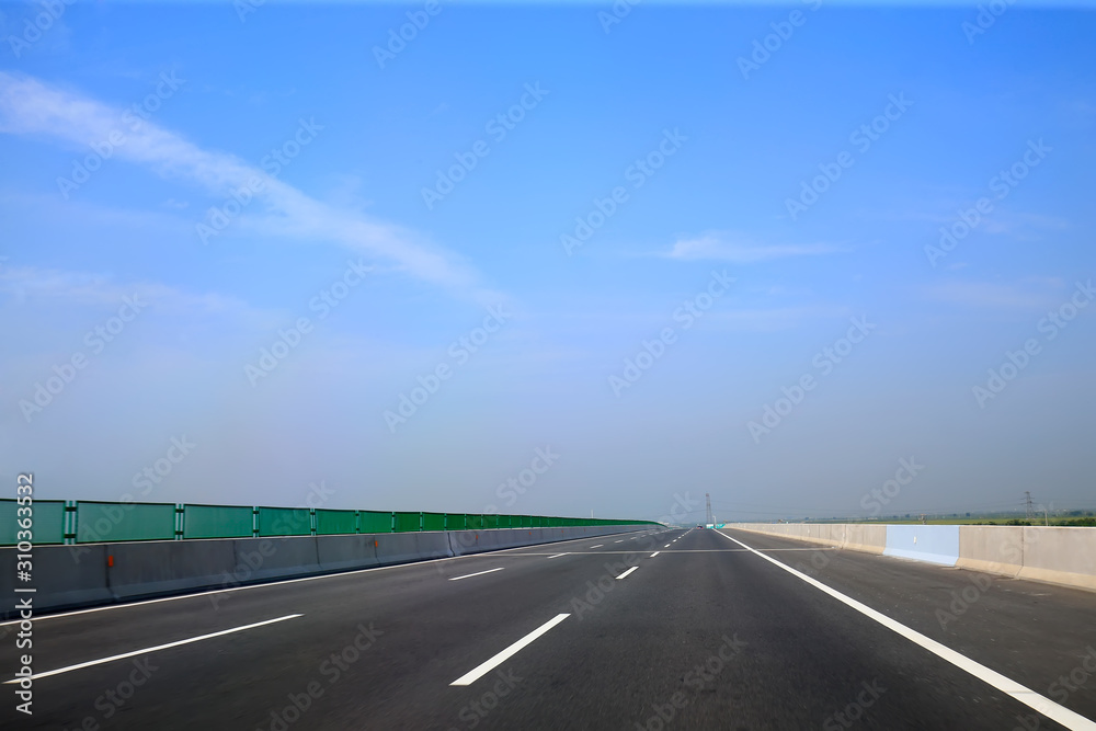 Beautiful highway, under the blue sky and white clouds Beautiful highway, under the blue sky and white clouds