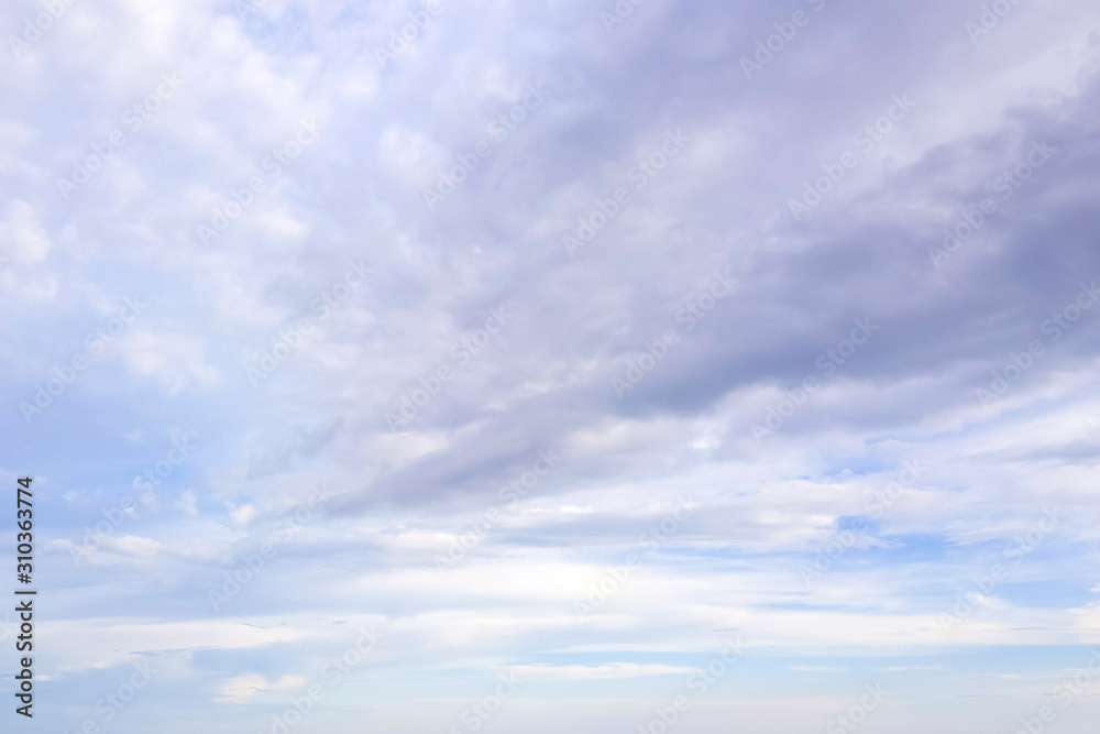 Naklejka premium Blue sky with soft white and gray clouds. Natural background and texture.