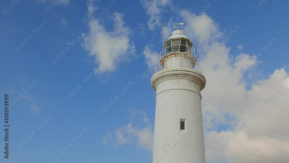 Lighthouse in the archaeological park near the Paphos against a bright blue sky with fast flying clouds. Lighthouse in the archaeological park near the Paphos against a bright blue sky with fast flying clouds.