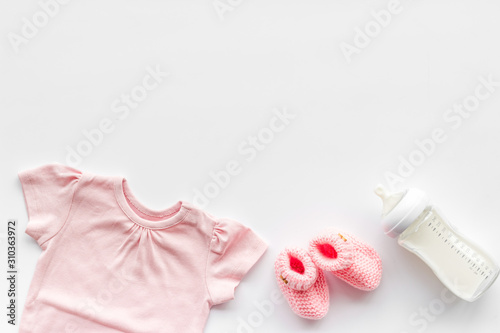 Baby background - pink color. Clothes, booties and accessories for newborn girl on white table top-down frame copy space © 9dreamstudio