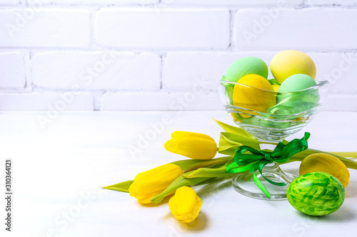 Easter green yellow eggs in the glass vase, copy space