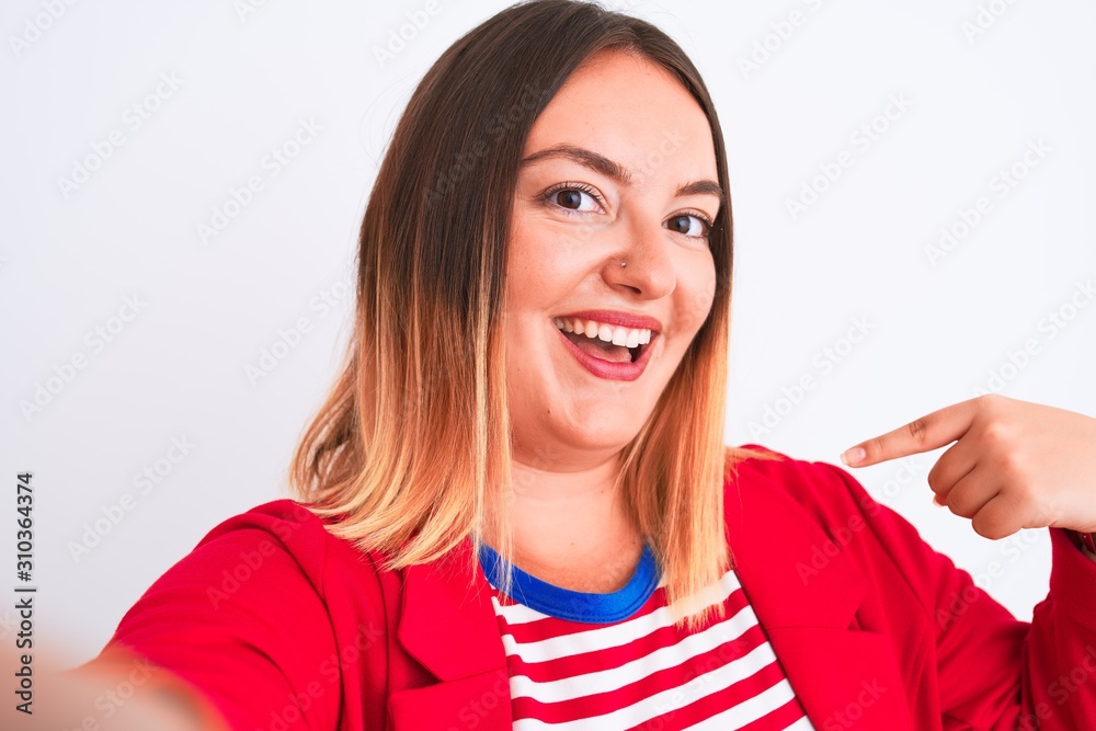 Beautiful woman wearing striped t-shirt and jacket standing over isolated white background very happy pointing with hand and finger Beautiful woman wearing striped t-shirt and jacket standing over isolated white background very happy pointing with hand and finger
