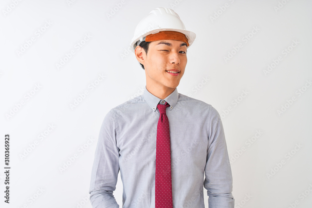 Chinese architect man wearing tie and helmet standing over isolated white background winking looking at the camera with sexy expression, cheerful and happy face. Chinese architect man wearing tie and helmet standing over isolated white background winking looking at the camera with sexy expression, cheerful and happy face.