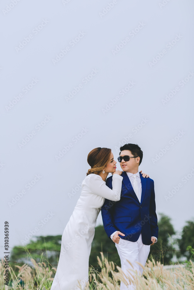 Young asian groom and bride posing and smiling for pre-wedding shot Young asian groom and bride posing and smiling for pre-wedding shot