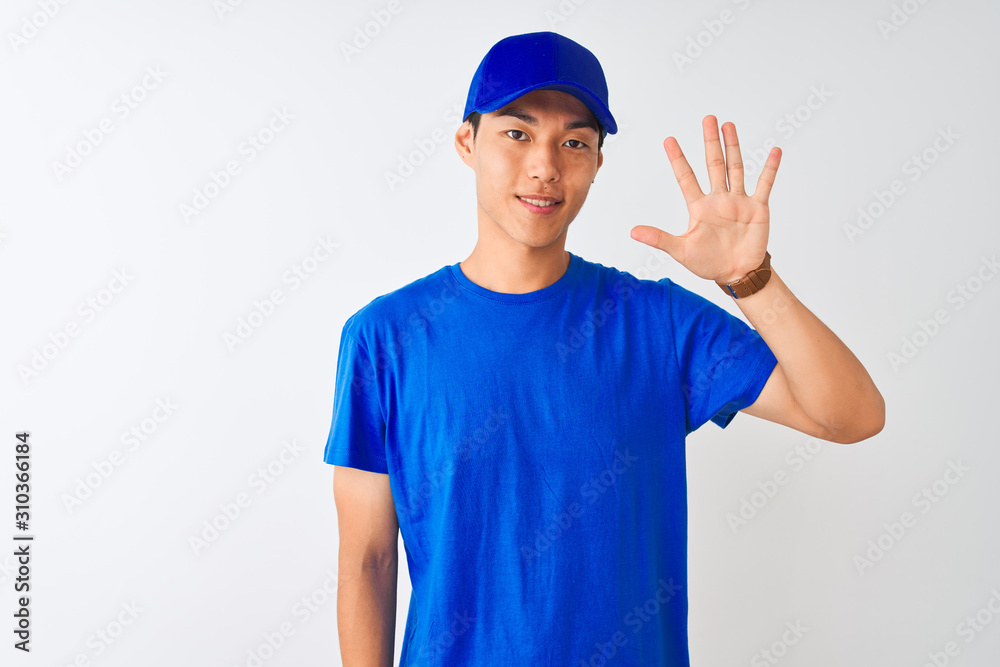 Chinese deliveryman wearing blue t-shirt and cap standing over isolated white background showing and pointing up with fingers number five while smiling confident and happy. Chinese deliveryman wearing blue t-shirt and cap standing over isolated white background showing and pointing up with fingers number five while smiling confident and happy.