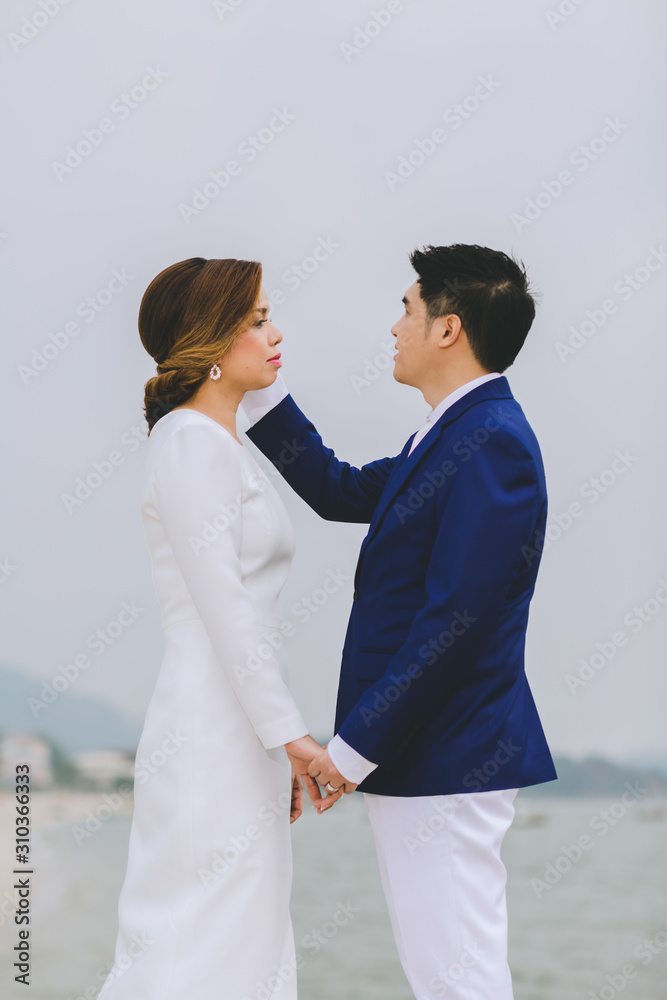 Young asian groom and bride posing and smiling for pre-wedding shot Young asian groom and bride posing and smiling for pre-wedding shot
