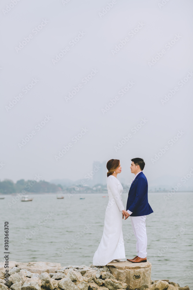 Young asian groom and bride posing and smiling for pre-wedding shot