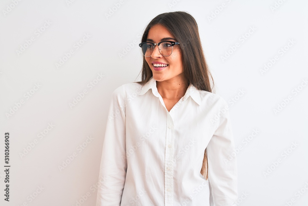 Young beautiful businesswoman wearing glasses standing over isolated white background looking away to side with smile on face, natural expression. Laughing confident. Young beautiful businesswoman wearing glasses standing over isolated white background looking away to side with smile on face, natural expression. Laughing confident.