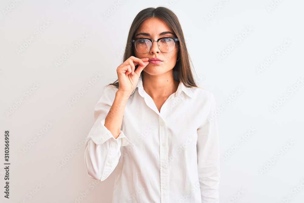 Young beautiful businesswoman wearing glasses standing over isolated white background mouth and lips shut as zip with fingers. Secret and silent, taboo talking