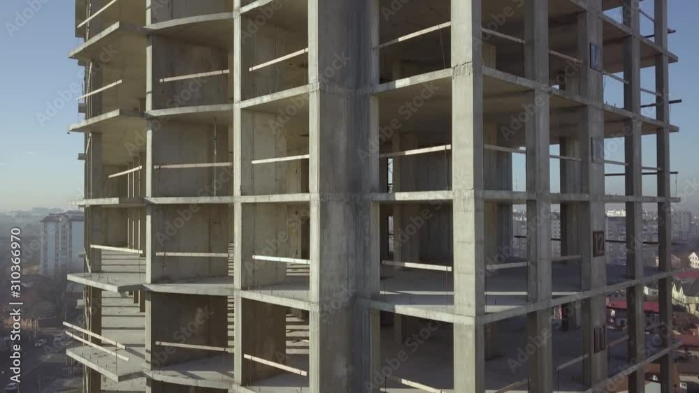 Aerial view of concrete frame of tall apartment building under construction in a city. Aerial view of concrete frame of tall apartment building under construction in a city.