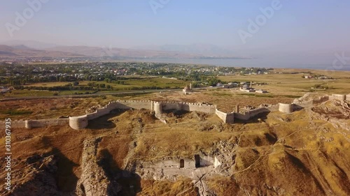 Historical Eastern fortress, Van Castle on rocky hill and mosques photo