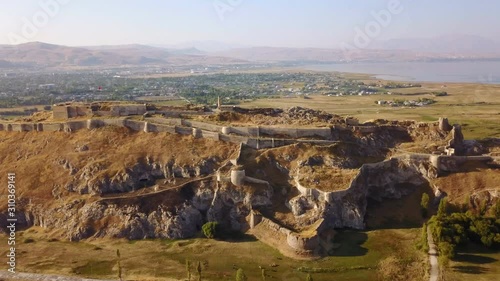 Historical Eastern fortress, Van Castle on rocky hill and mosques photo